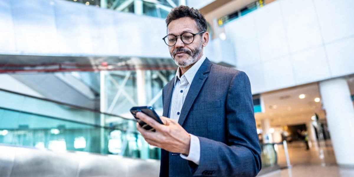 man walking while looking at phone