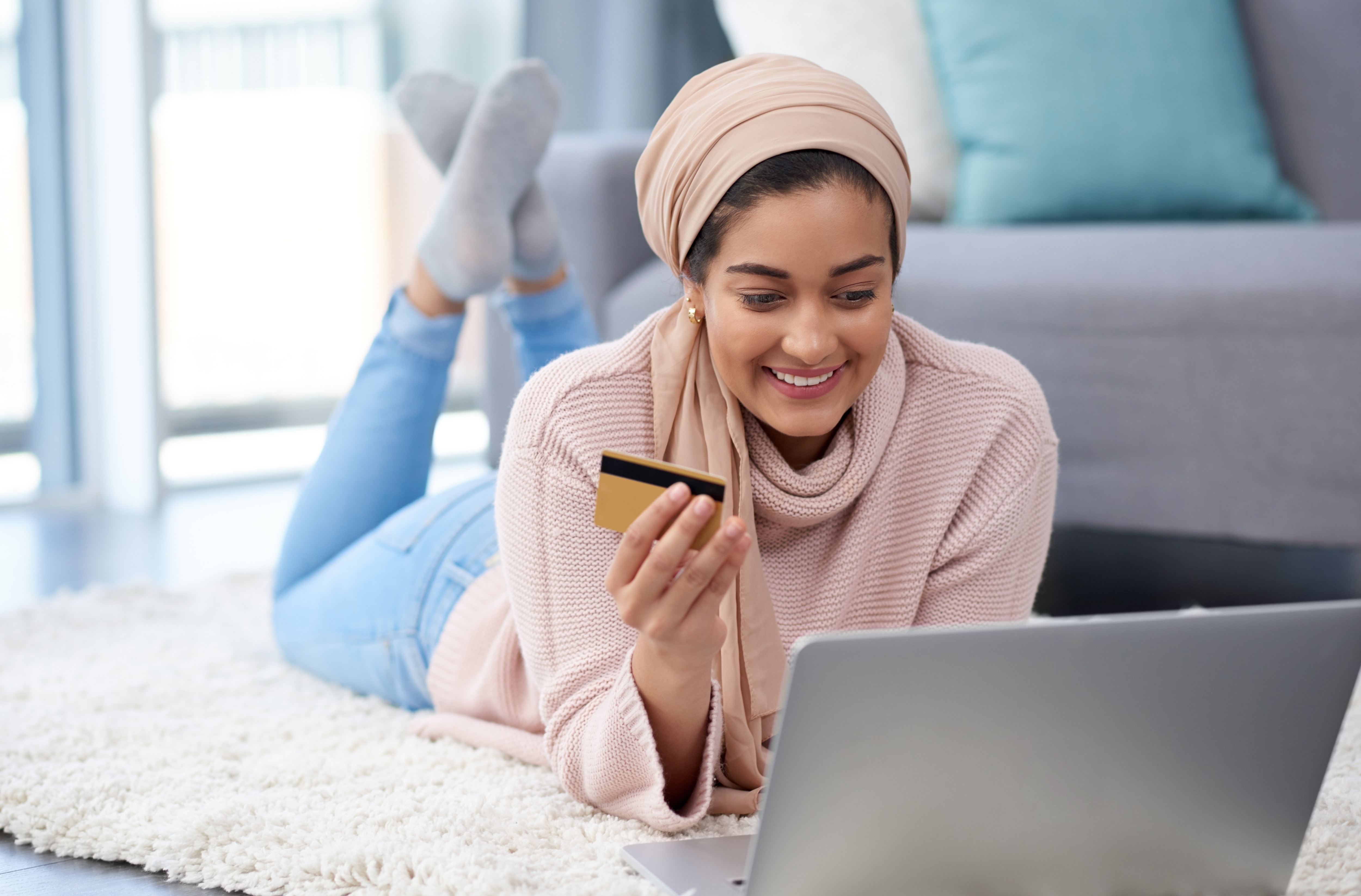 woman holding purchasing card smiling while making a business purchase