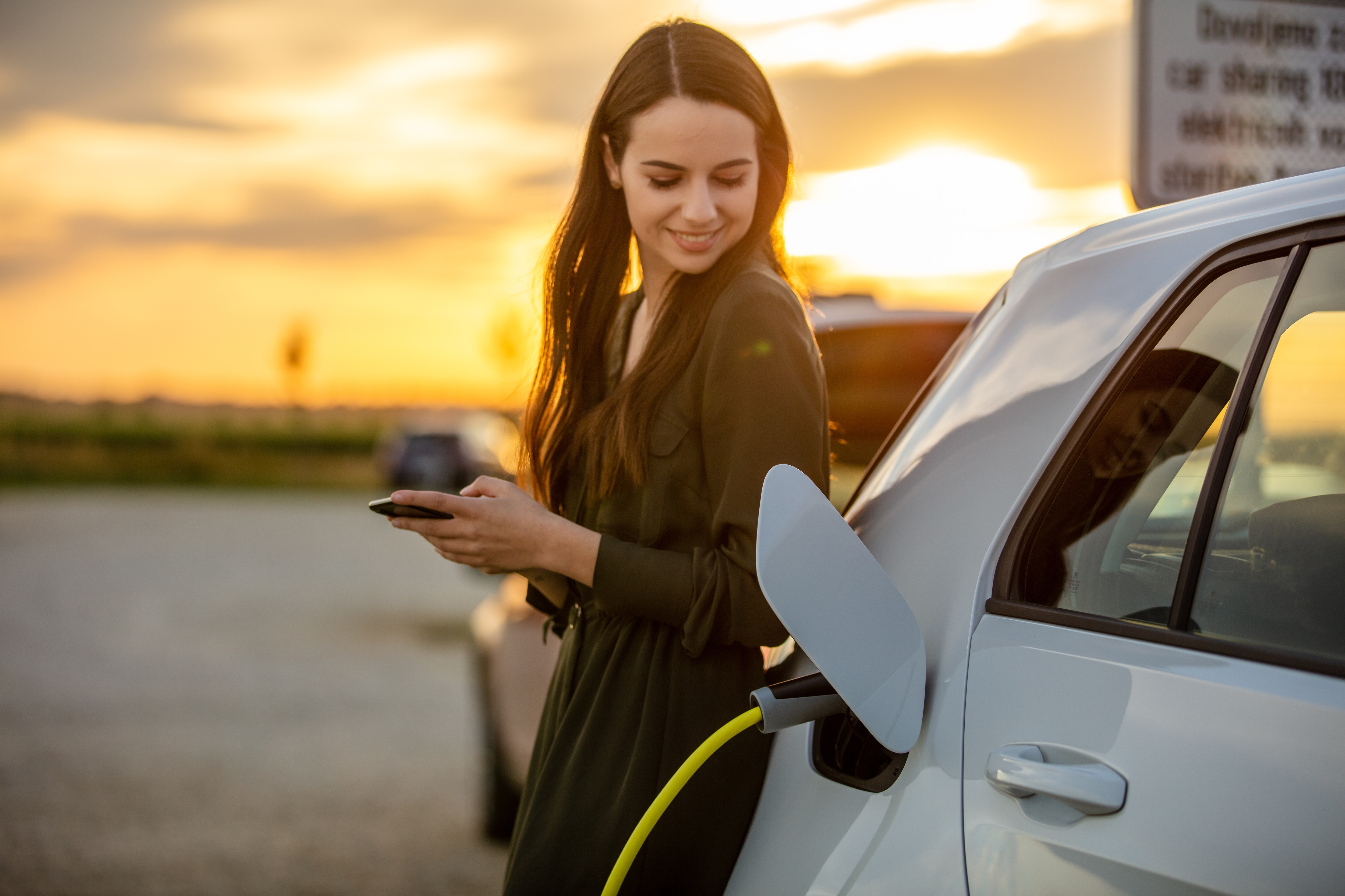 Woman charging electric car