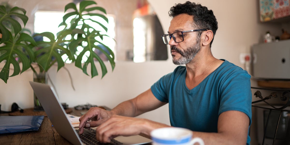 man wearing glasses looking at computer