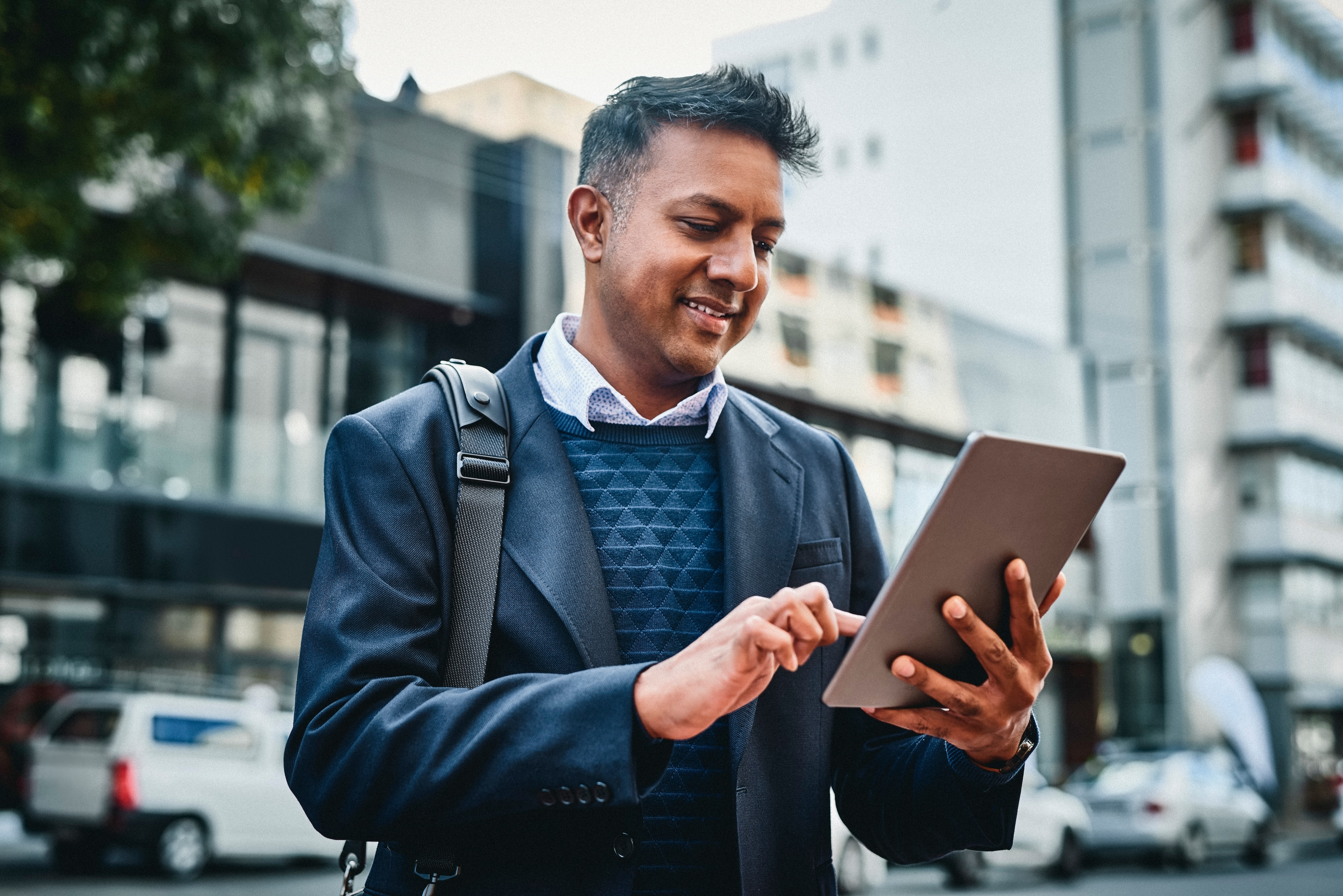 a man on the street looking at his tablet