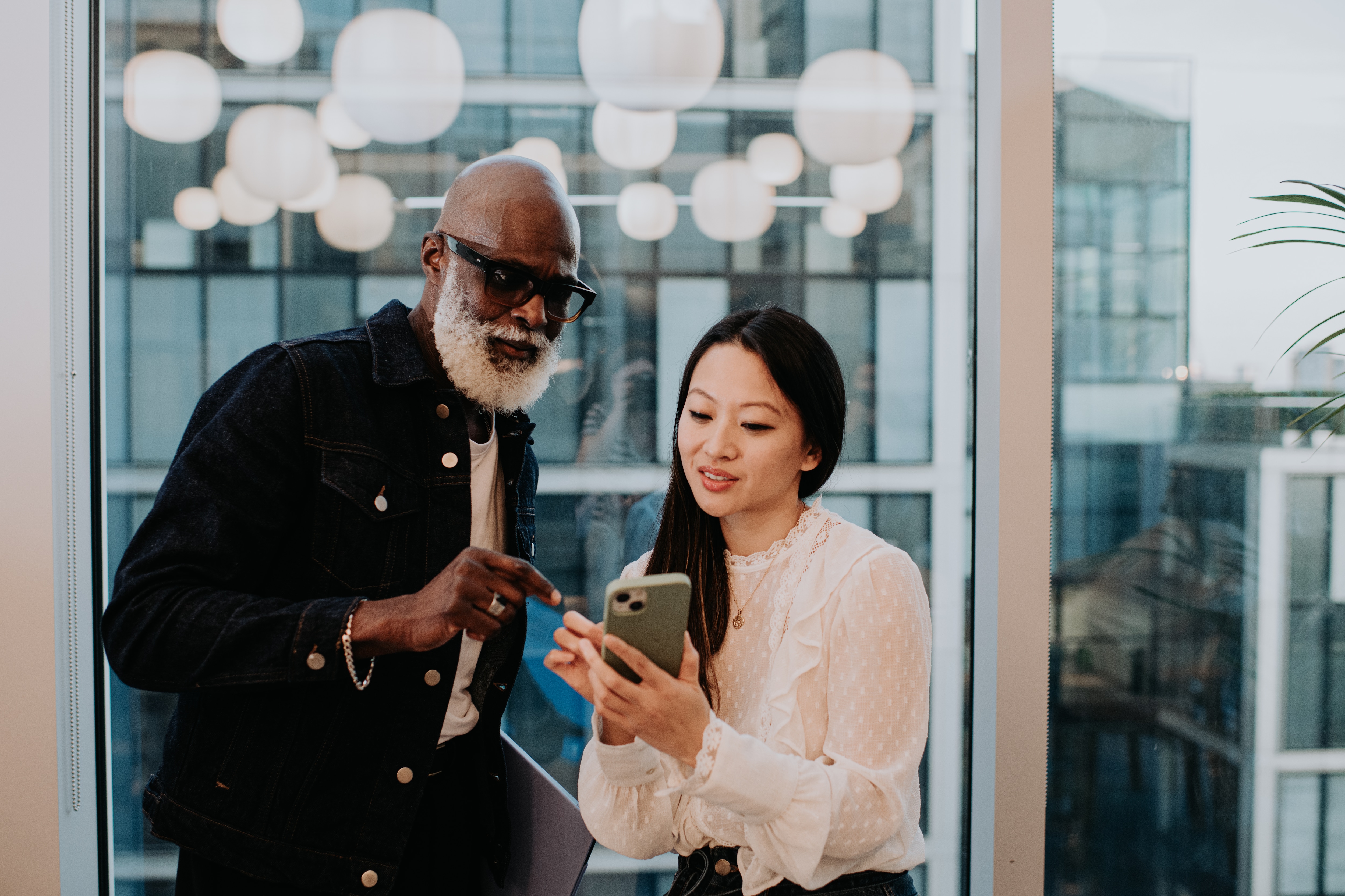 Man and woman looking at the business spending trends on their phone