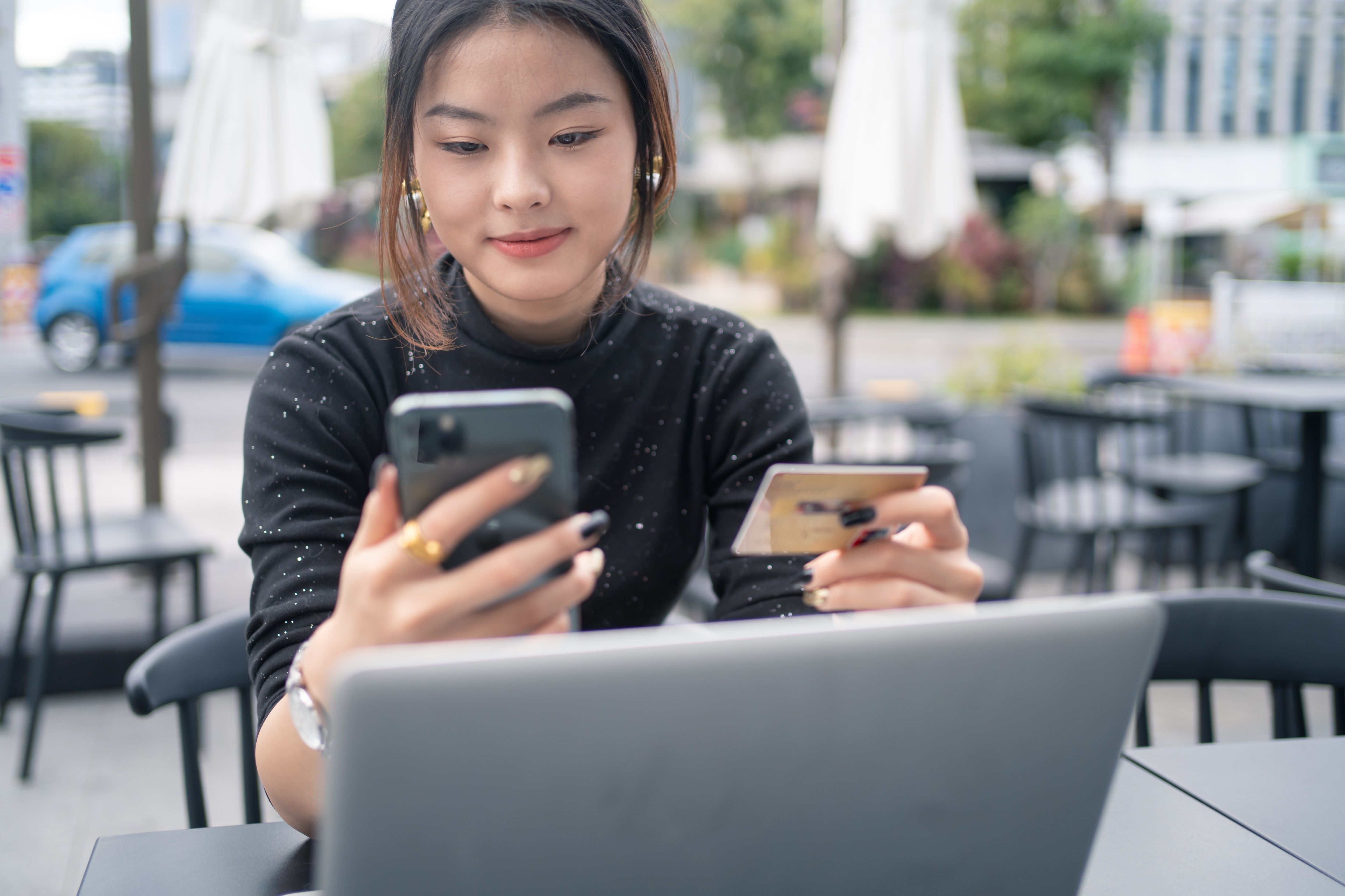 a woman holding a cell phone and a credit card