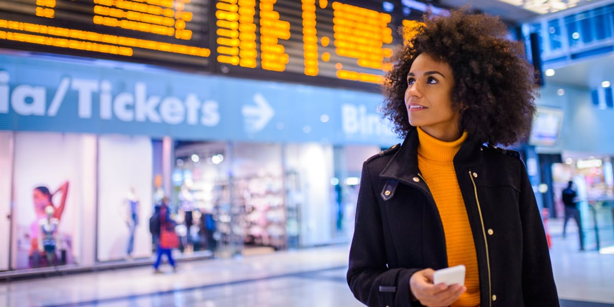 woman in airport holding phone